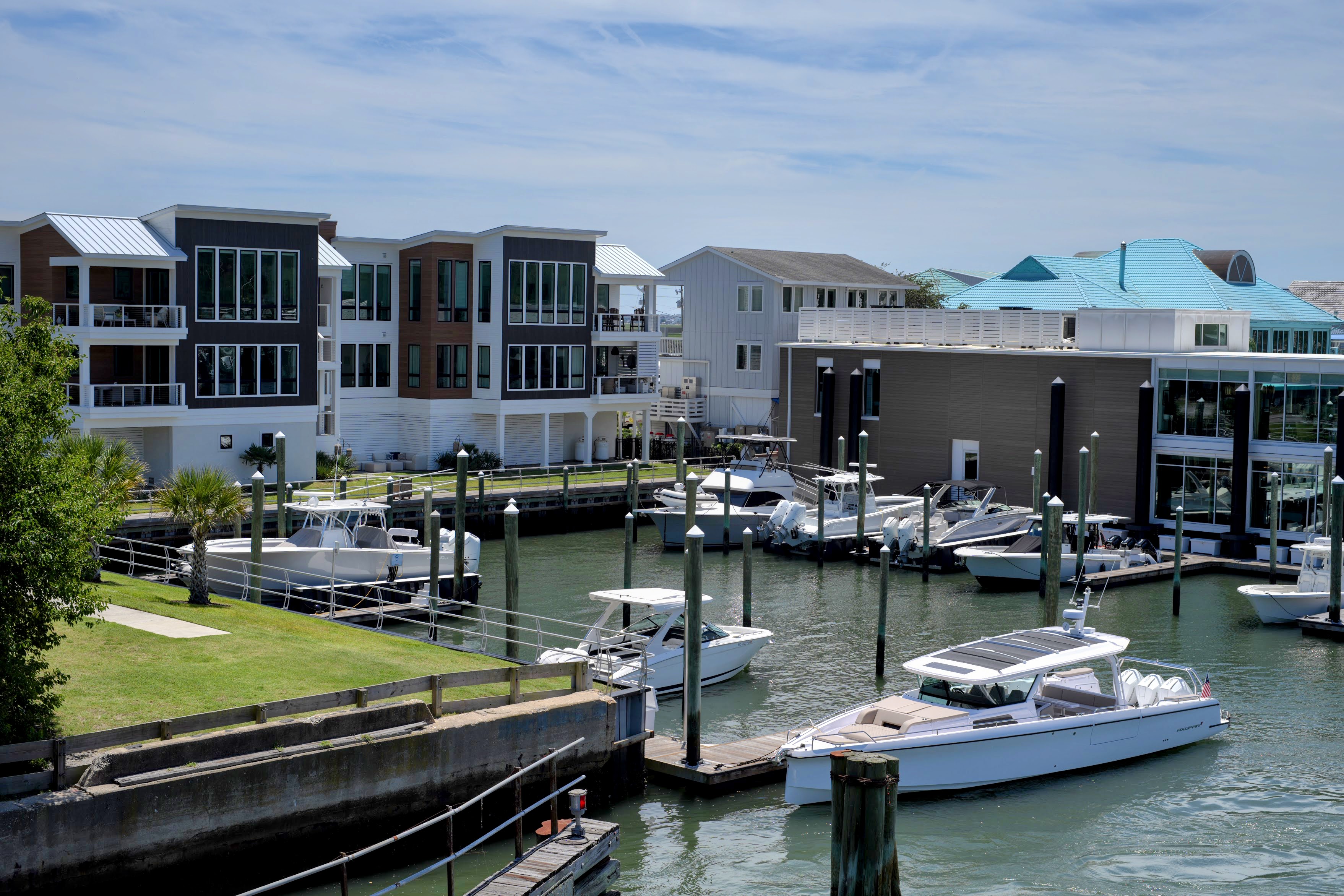 Modern waterfront condos and boat docks along a marina channel in Wrightsville Beach, NC.