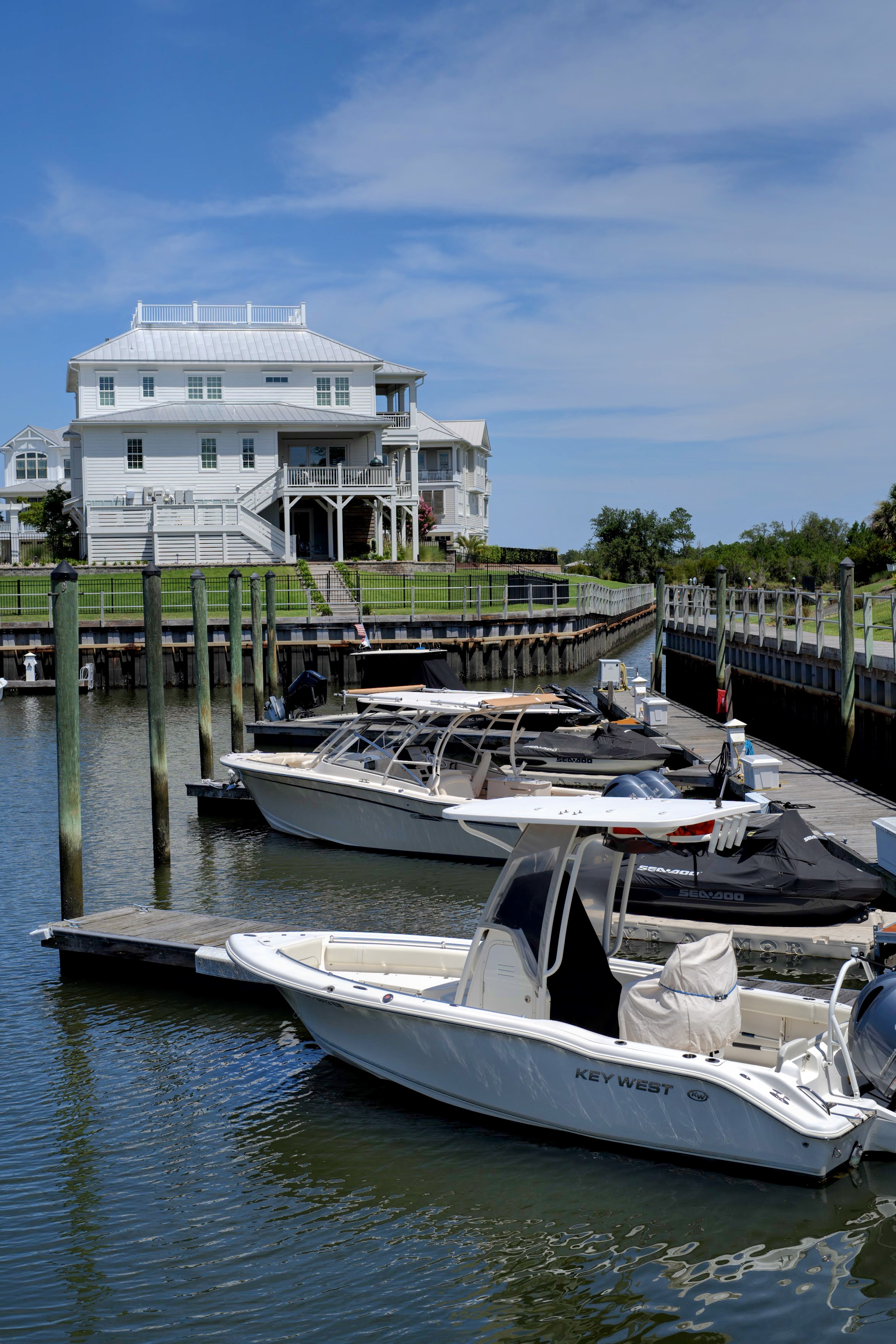 Waterfront home and private boat dock with a Key West center-console boat in a Wrightsville Beach harbor, NC.