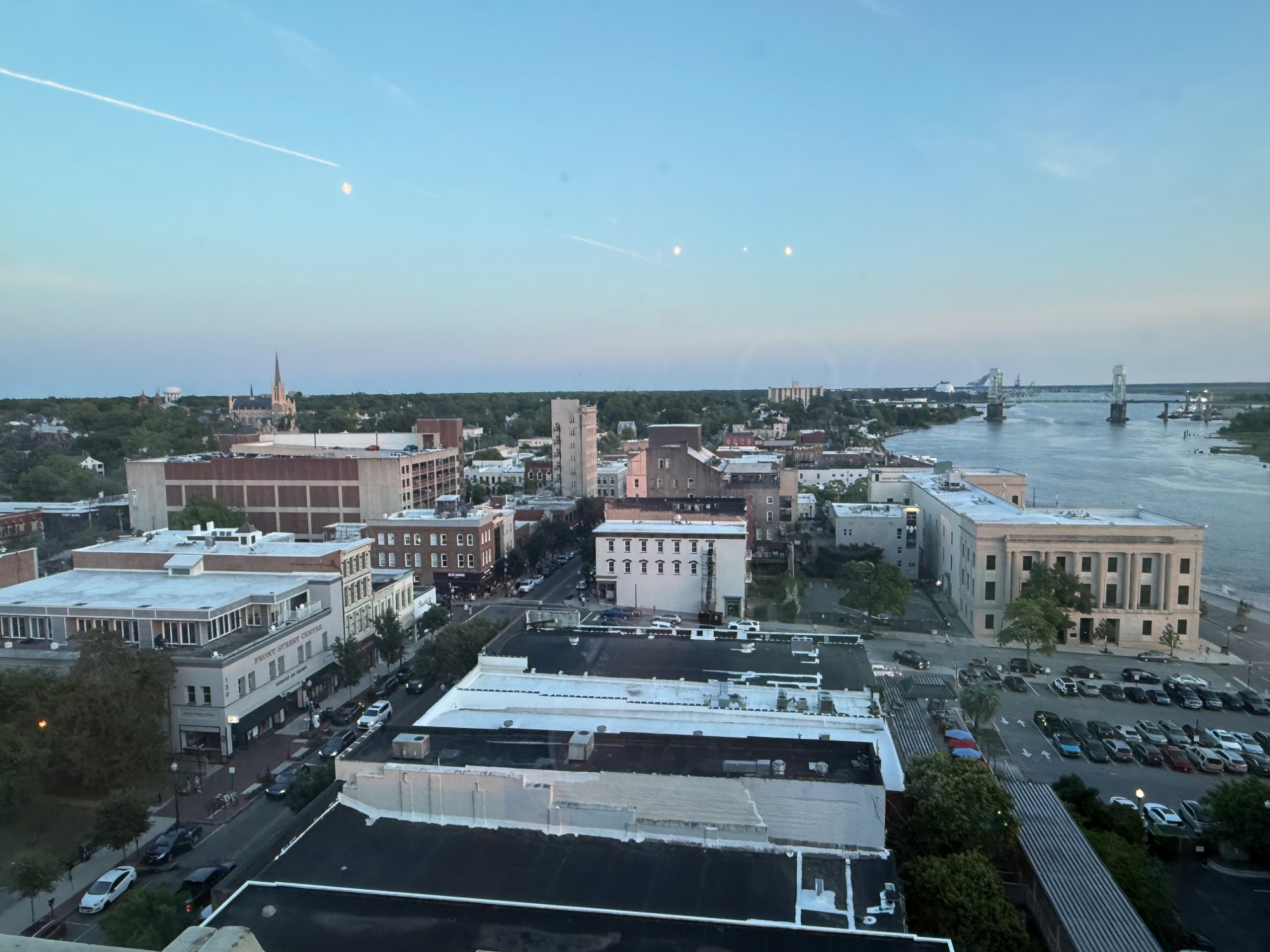 Aerial view of downtown Wilmington, North Carolina, with historic buildings, the Cape Fear River, and the Cape Fear Memorial Bridge.